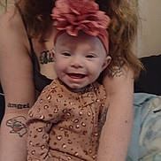 Amelia joined the competition — help win amazing prizes! baby, smiling, headband, leopard_print, pajamas, tattoos, adult, arms, indoor, cozy, happy, person, clothing, face, child, woman, hair, skin, holding, candid