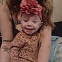 baby, smiling, headband, leopard_print, pajamas, tattoos, adult, arms, indoor, cozy, happy, person, clothing, face, child, woman, hair, skin, holding, candid