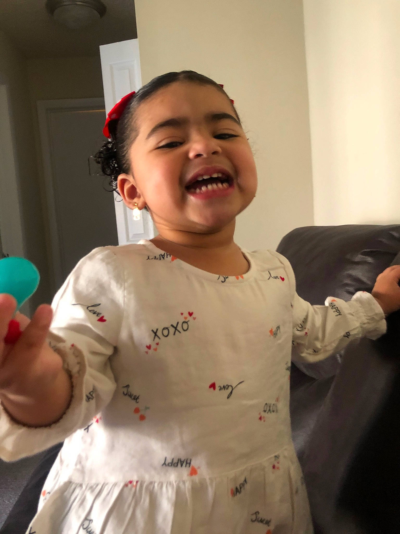 Mia is registered to the contest to win money with this photo: arm, baby, child, finger, gesture, hand, happy, person, room, smile, thumb, toddler, tooth