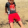 Jason is registered to the contest to win money with this photo: child, boy, curly_hair, black_tshirt, red_shorts, barefoot, sand, outdoor, sunny, portrait, casual_clothing, young, serious_expression, playing_outdoors, dirt_on_skin, summer, daylight, relaxed_pose, sand_on_feet, natural_light