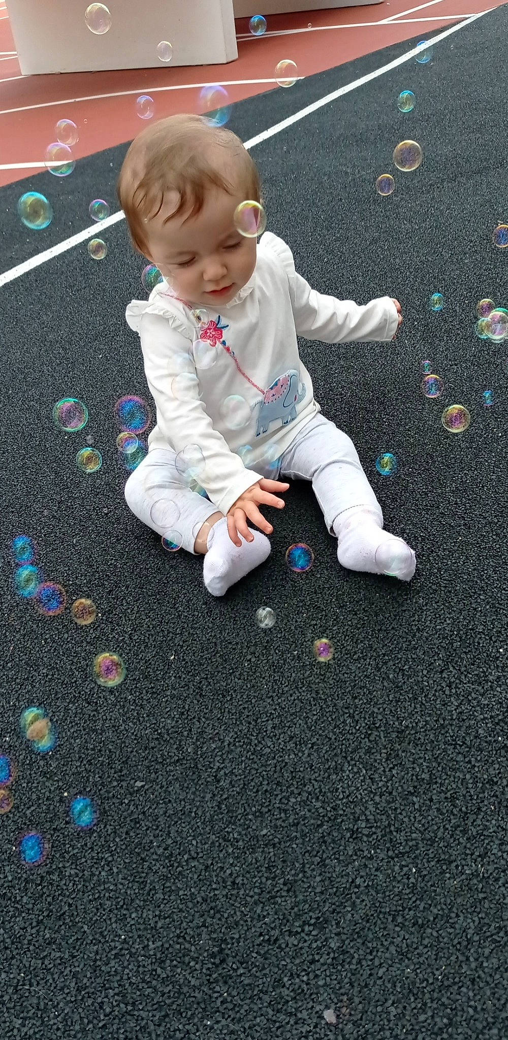 Assia participe au concours pour gagner de l'argent avec cette photo : asphalt, baby, baby_toddler_clothing, child, circle, electric_blue, floor, flooring, foot, fun, grass, pattern, person, play, product, road_surface, sidewalk, sitting, tar, toddler