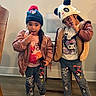 beanie, cartoon_clothing, casual, child, floor, furniture, happy, hat, indoor, jacket, jeans, kids, panda_hat, person, playful_pose, smiling, socks, standing, wall, wooden_floor