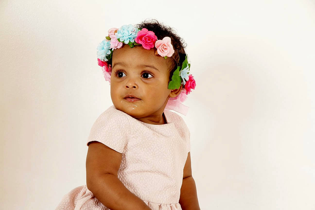 Mariana participe au concours pour gagner de l'argent avec cette photo : baby, baby_toddler_clothing, cheek, child, cut_flowers, dress, eyelash, fashion_accessory, flash_photography, flower, gesture, hair_accessory, happy, headband, headpiece, headwear, magenta, person, petal, plant