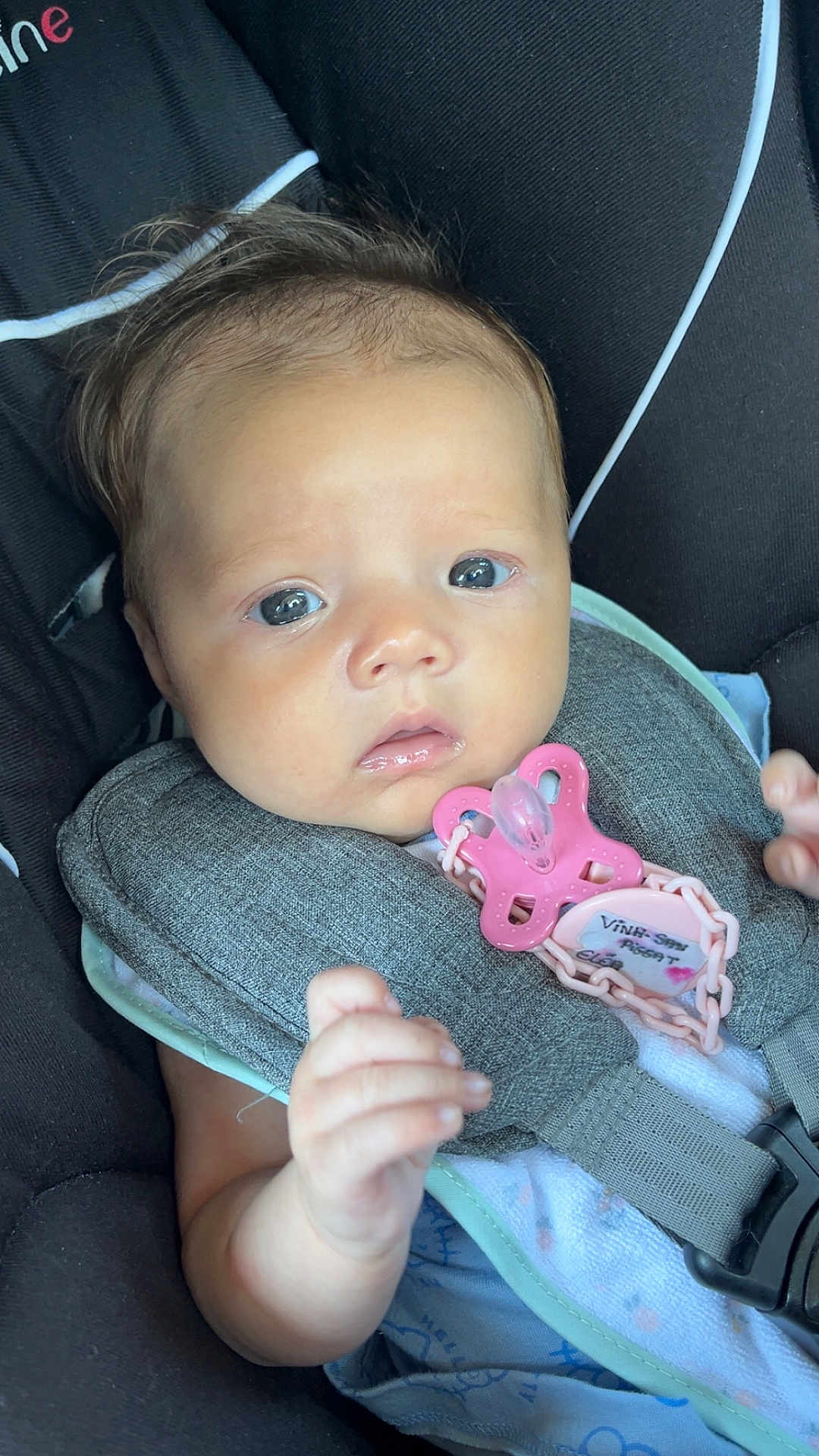 Eléa a rejoint le concours — aidez-le/la à gagner de superbes lots ! baby, infant, car_seat, pacifier, child, face, hand, clothing, seatbelt, closeup, skin, expression, cute, safety, newborn, young_child, indoor, portrait, person, pink