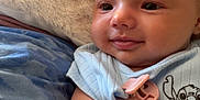 Eléa a rejoint le concours — aidez-le/la à gagner de superbes lots ! arm, baby, blanket, blue_clothing, child, closeup, cute, fabric, face, happy, head, indoors, infant, lying_down, onesie, pacifier_clip, person, skin, smiling, soft_texture