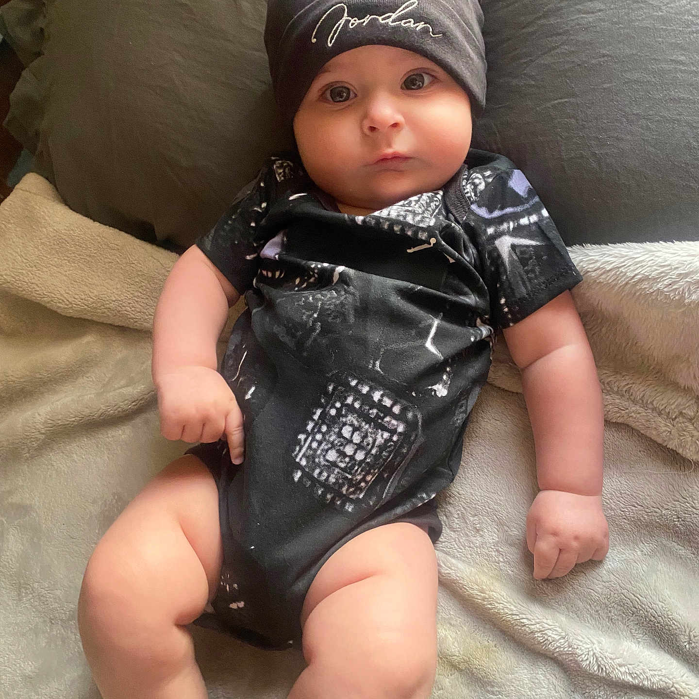 Leonidas joined the competition — help win amazing prizes! arms, baby, beanie, bed, blanket, child, clothing, cozy, cute, expression, eyes, face, indoor, infant, legs, onesie, pillow, resting, skin, soft