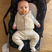 Danaë participe au concours pour gagner de l'argent avec cette photo : baby, baby_rocker, casual, child, comfort, cozy, cute, feet, flooring, homedecor, indoor, infant, knit_pants, pacifier, person, seated, star_pattern, vest, white_socks, wooden_floor