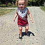 Delilah joined the competition — help win amazing prizes! toddler, child, curly_hair, white_bow, cheerleading_outfit, maroon, white, dress, shoes, gravel_path, outdoor, sunlight, shadow, happy, walking, confident, nature, trees, daytime, person