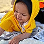 Léon participe au concours pour gagner de l'argent avec cette photo : baby, beach, blanket, child, closeup, clothing, cute, face, hand, happy, infant, outdoor, person, portrait, relaxing, sand, smiling, sunlight, towel, yellow_hood