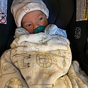 Vicente joined the competition — help win amazing prizes! baby, infant, pacifier, blanket, hat, car_seat, teddy_bear_pattern, wrapped, cozy, cute, child, newborn, indoor, soft_texture, face, sitting, warm, clothing, sleepy, comfort