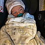 baby, infant, pacifier, blanket, hat, car_seat, teddy_bear_pattern, wrapped, cozy, cute, child, newborn, indoor, soft_texture, face, sitting, warm, clothing, sleepy, comfort