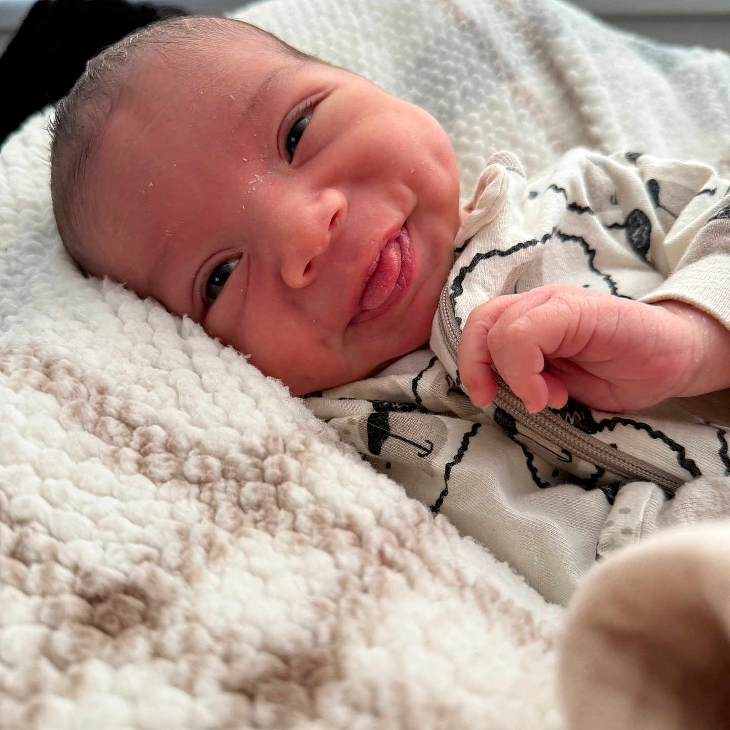Vicente is registered to the contest to win money with this photo: baby, blanket, clothing, cozy, cute, face, hand, happy, indoors, infant, light, newborn, pattern, portrait, smiling, soft, texture, tongue, umbrellas, window