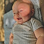 baby, smiling, face, skin, child, person, blanket, clothing, short_sleeve, arm, cheek, happy, infant, light, shadow, texture, indoor, closeup, cute, portrait