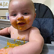 Elliot joined the competition — help win amazing prizes! baby, high_chair, food, messy, smiling, face, hand, infant, child, indoor, feeding, cute, skin, table, expression, person, happy, young, mess, kitchen