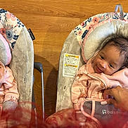 Keilani joined the competition — help win amazing prizes! baby, infant, smiling, pink_clothing, baby_swing, floral_pattern, giraffe_print, hand, wooden_floor, toddler, happy, cute, indoors, child, person, seat, comfort, cozy, portrait, expression