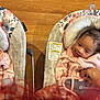baby, infant, smiling, pink_clothing, baby_swing, floral_pattern, giraffe_print, hand, wooden_floor, toddler, happy, cute, indoors, child, person, seat, comfort, cozy, portrait, expression