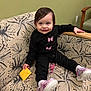Olivia joined the competition — help win amazing prizes! toddler, child, smiling, black_clothing, butterfly_print, pink_shoes, couch, floral_pattern, indoor, happy, young_child, seated, holding_object, pacifier_clip, socks, wooden_armrest, green_wall, light_switch, cute, portrait