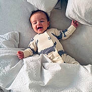 Oliver is registered to the contest to win money with this photo: baby, smiling, bed, blanket, pillow, onesie, infant, happy, lying_down, sleepwear, cozy, cute, child, indoor, soft, resting, portrait, comfort, toddler, sleep