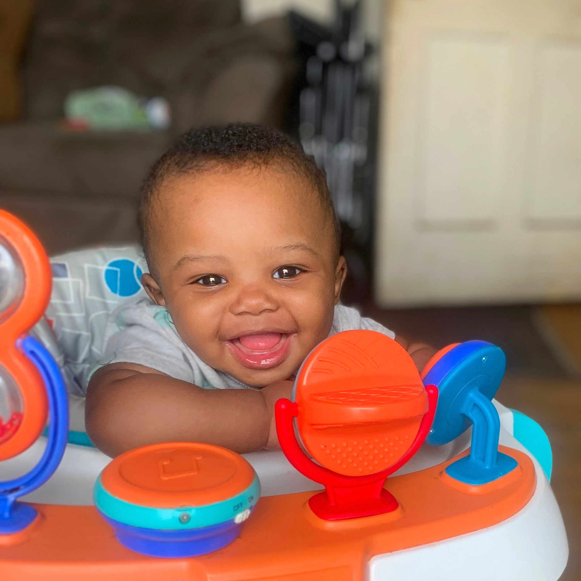 Nakoa joined the competition — help win amazing prizes! baby, babylaughing, bodypart, clothing, cutlery, face, furniture, happy, head, indoors, laughing, mouth, person, photography, play, portrait, smile, t_shirt, teeth, toy