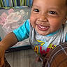 toddler, child, smile, face, eyes, teeth, clothing, shirt, playpen, toy, indoor, happy, cute, baby, person, closeup, hand, floor, colorful, expression