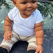 Desmoni joined the competition — help win amazing prizes! toddler, child, baby, white_shirt, striped_pants, black_shoes, car_hood, outdoor, trees, reflection, smiling, cute, sitting, hand, footwear, curly_hair, chubby_cheeks, daylight, casual_clothing, playful