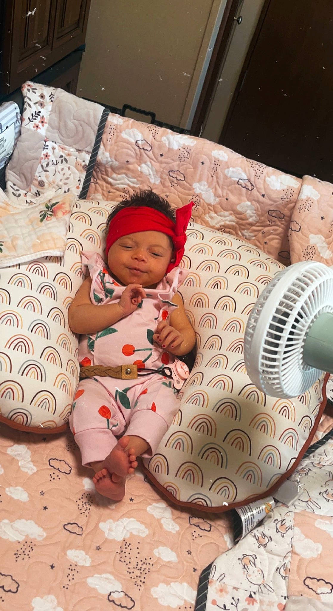 Saige is registered to the contest to win money with this photo: baby, baby_products, baby_toddler_clothing, bed_sheet, bedding, cap, child, circle, comfort, couch, fashion_accessory, flooring, headwear, linens, pattern, person, pillow, product, room, sitting