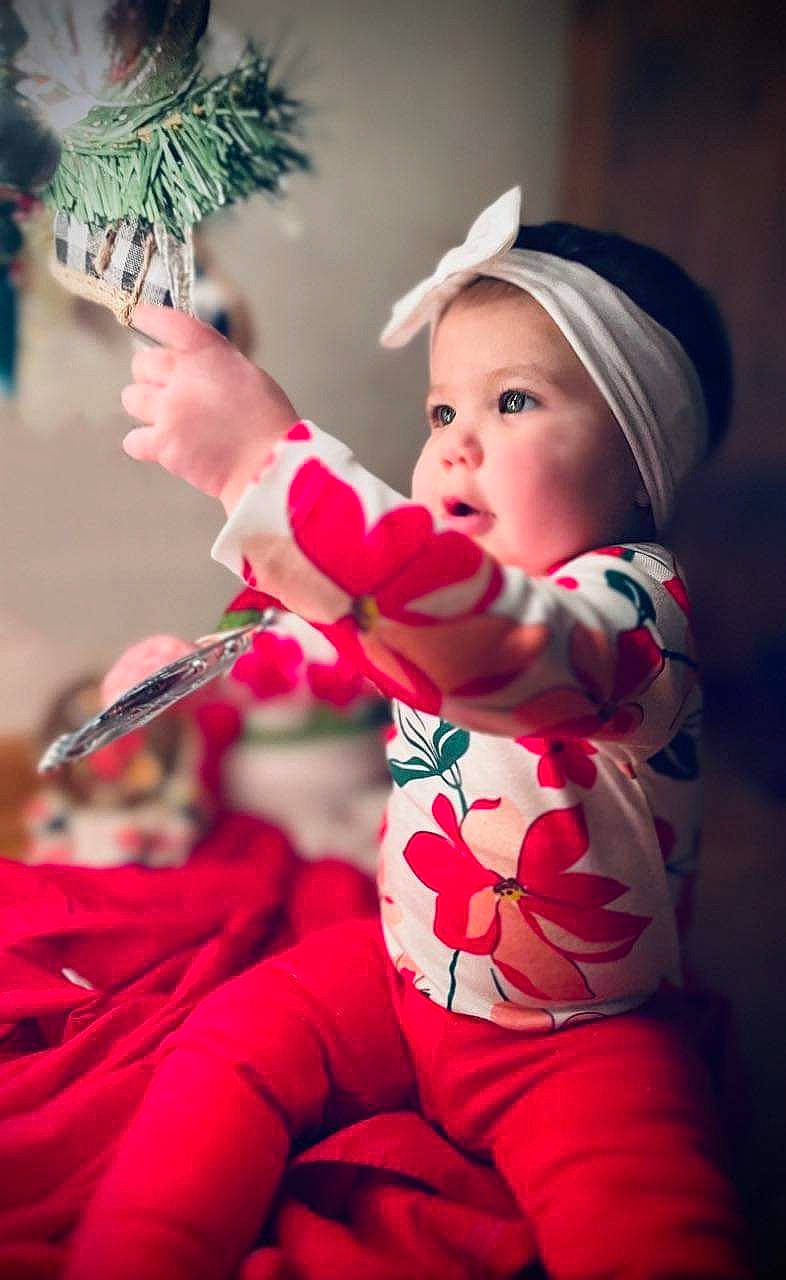 Iyla is registered to the contest to win money with this photo: baby, baby_toddler_clothing, child, christmas, christmas_decoration, christmas_eve, christmas_ornament, event, fun, happy, headwear, holiday, human, magenta, person, pink, plant, red, santa_claus, skin