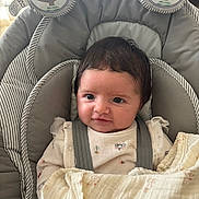 Valentina a rejoint le concours — aidez-le/la à gagner de superbes lots ! baby, infant, child, face, eyes, dark_hair, smile, cheeks, baby_bouncer, seat, blanket, swaddle, straps, onesie, plush_bear, toy, indoor, soft_fabric, portrait, close_up