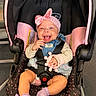 Leilani joined the competition — help win amazing prizes! baby, child, car_seat, pink_bow, denim_overalls, purple_socks, toy, happy, smiling, infant, seatbelt, indoor, cute, headband, clothing, person, sitting, childrens_toy, footwear, playful