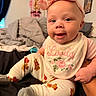 baby, child, infant, headband, bow, bib, clothing, cute, smile, face, person, indoors, bed, blanket, socks, legs, hand, portrait, happy, toddler