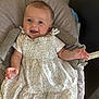baby, child, smiling, dress, seat, cushion, indoor, happy, person, infant, clothing, fabric, skin, hand, head, hair, floor, carpet, baby_seat, expression
