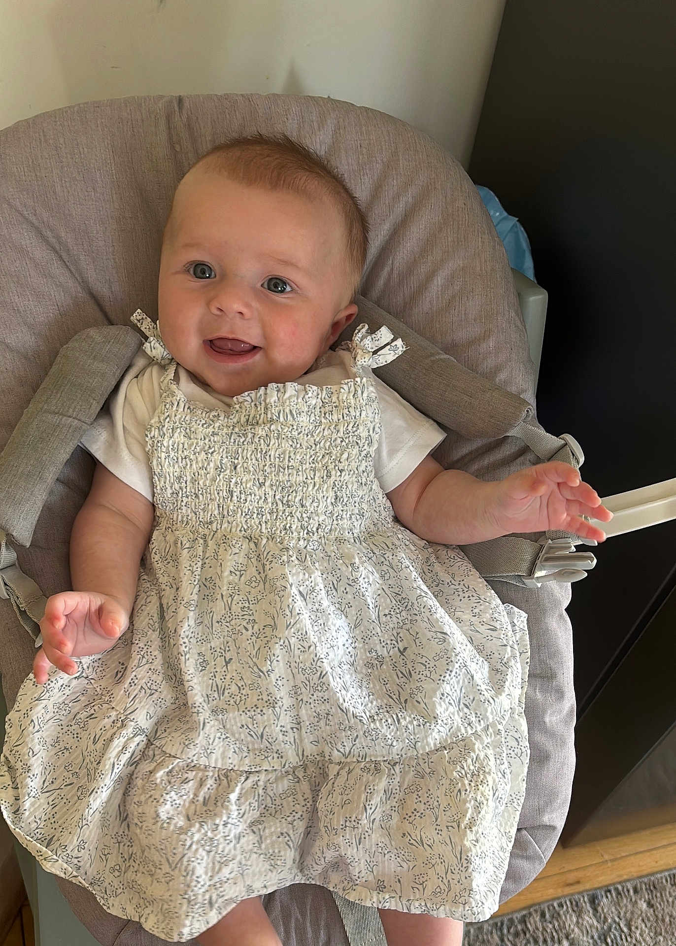Amelia joined the competition — help win amazing prizes! baby, child, smiling, dress, seat, cushion, indoor, happy, person, infant, clothing, fabric, skin, hand, head, hair, floor, carpet, baby_seat, expression