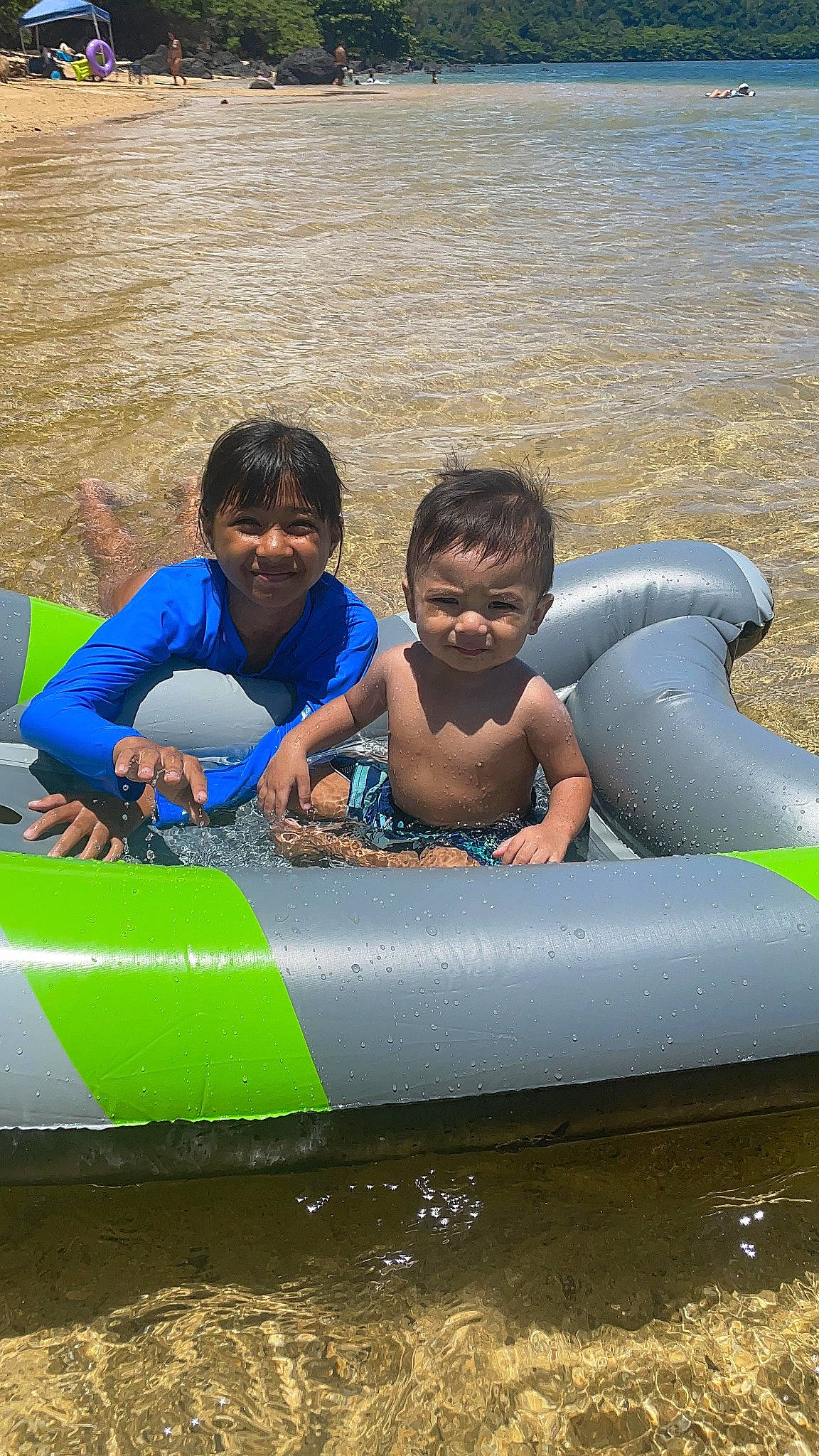 Kade is registered to the contest to win money with this photo: aqua, boats_and_boating_equipment_and_supplies, child, fun, happy, inflatable, joy, leisure, lifejacket, outdoor_recreation, person, personal_protective_equipment, play, product, recreation, shorts, smile, toddler, water, water_transportation