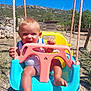 toddler, child, swing, outdoor, sunny_day, blue_sky, grass, mountains, plastic_swing, playground, happy, smiling, barefoot, nature, summer, fence, wooden_shed, rope, greenery, sunlight