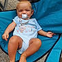 baby, child, pacifier, blue_onesie, folding_chair, outdoor, happy, smile, skin, foot, hand, face, blond_hair, fabric, seat, relaxed, cute, infant, clothing, texture
