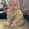 baby, child, hoodie, carpet, smile, indoor, person, dog, couch, plant, window, sitting, happy, cozy, floor, hand, casual_clothing, home, relaxed, portrait