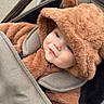 baby, child, stroller, fuzzy_clothing, hood, bear_ears, cute, outdoor, bundle_up, seatbelt, cozy, face, infant, warm_clothing, portrait, expression, child_in_stroller, winter_wear, soft_texture, curious_look
