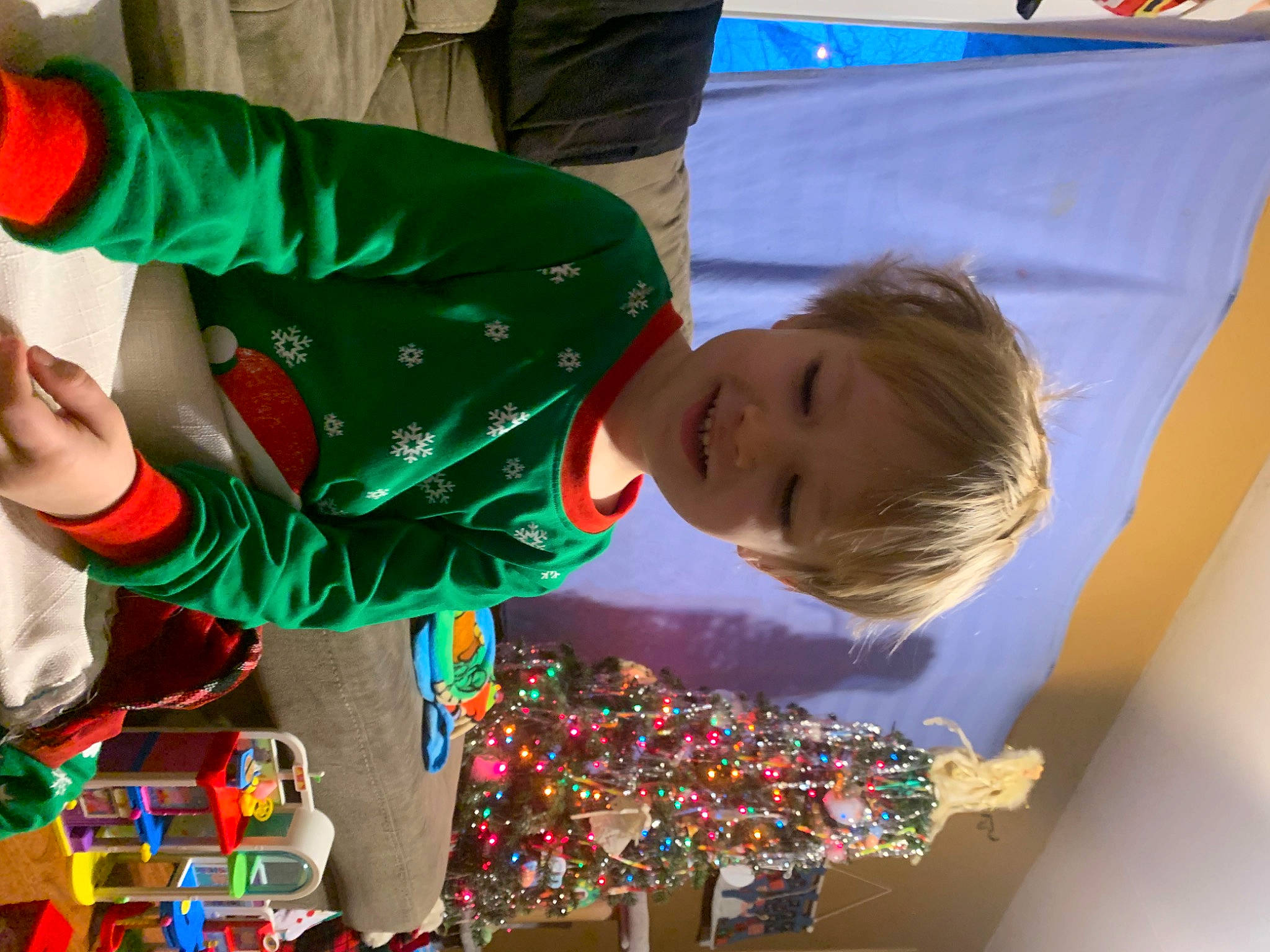 Rory is registered to the contest to win money with this photo: child, christmas, christmas_eve, event, fictional_character, fun, green, happy, holiday, joy, leisure, party, person, play, recreation, room, smile, t_shirt, toddler