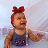baby, child, red_bow, water, milky_bath, smiling, happy, sleeveless_shirt, face, hand, sitting, lime_slice, water_stream, cute, portrait, infant, headband, skin, playful, indoors