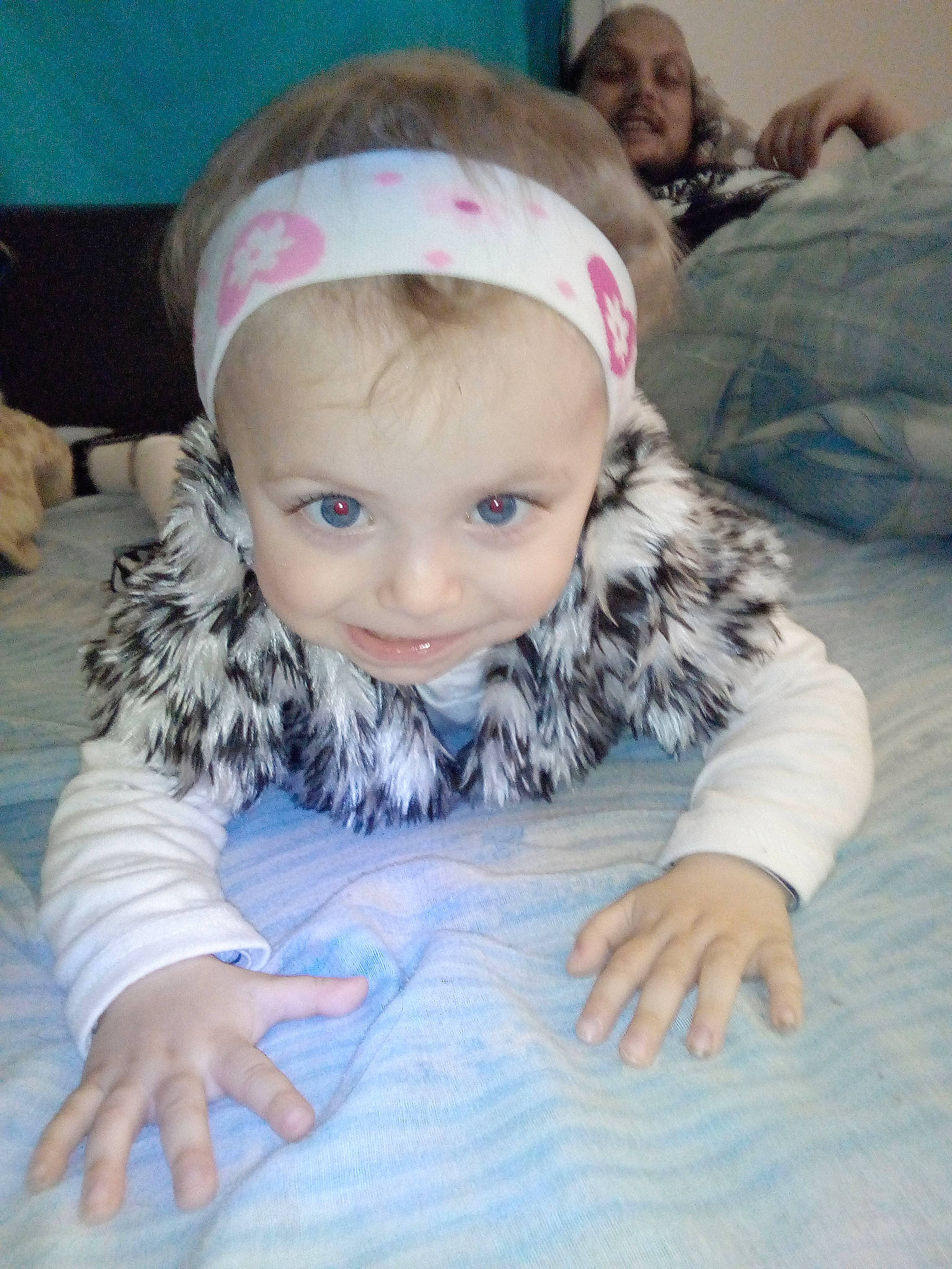 Iliana participe au concours pour gagner de l'argent avec cette photo : child, comfort, eye, face, fashion_accessory, flooring, fun, fur, happy, linens, pattern, person, personal_protective_equipment, portrait_photography, room, selfie, sitting, sleeve, smile, toddler