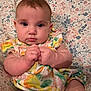 baby, infant, child, face, hands, clothing, patterned_background, floral, colorful, cute, portrait, sitting, skin, expression, young, person, indoors, dress, fingers, closeup