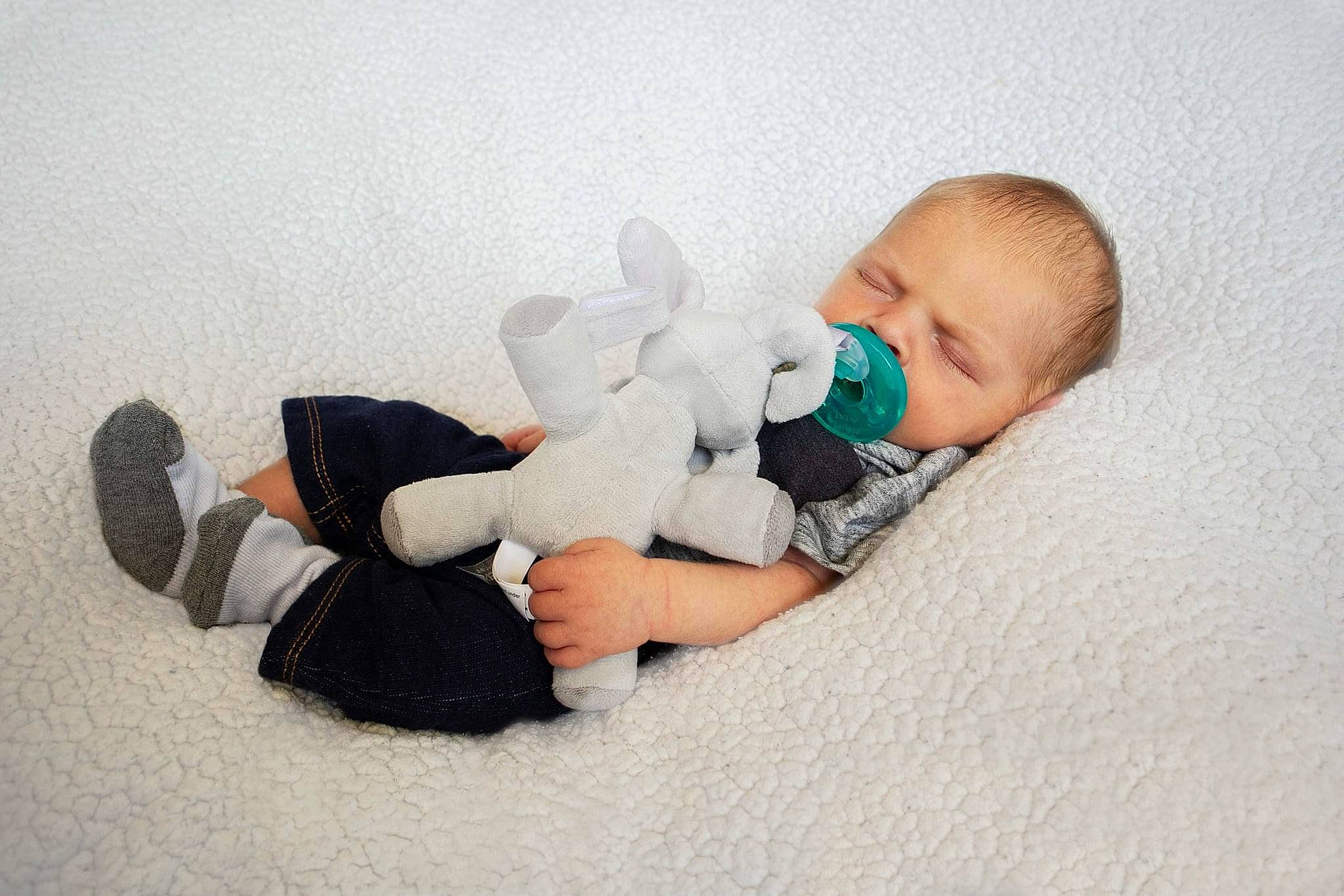 Mikael is registered to the contest to win money with this photo: baby, baby_sleeping, child, comfort, flooring, foot, fun, fur, happy, human_body, human_leg, knee, leg, person, room, sitting, skin, stuffed_toy, thigh, toddler