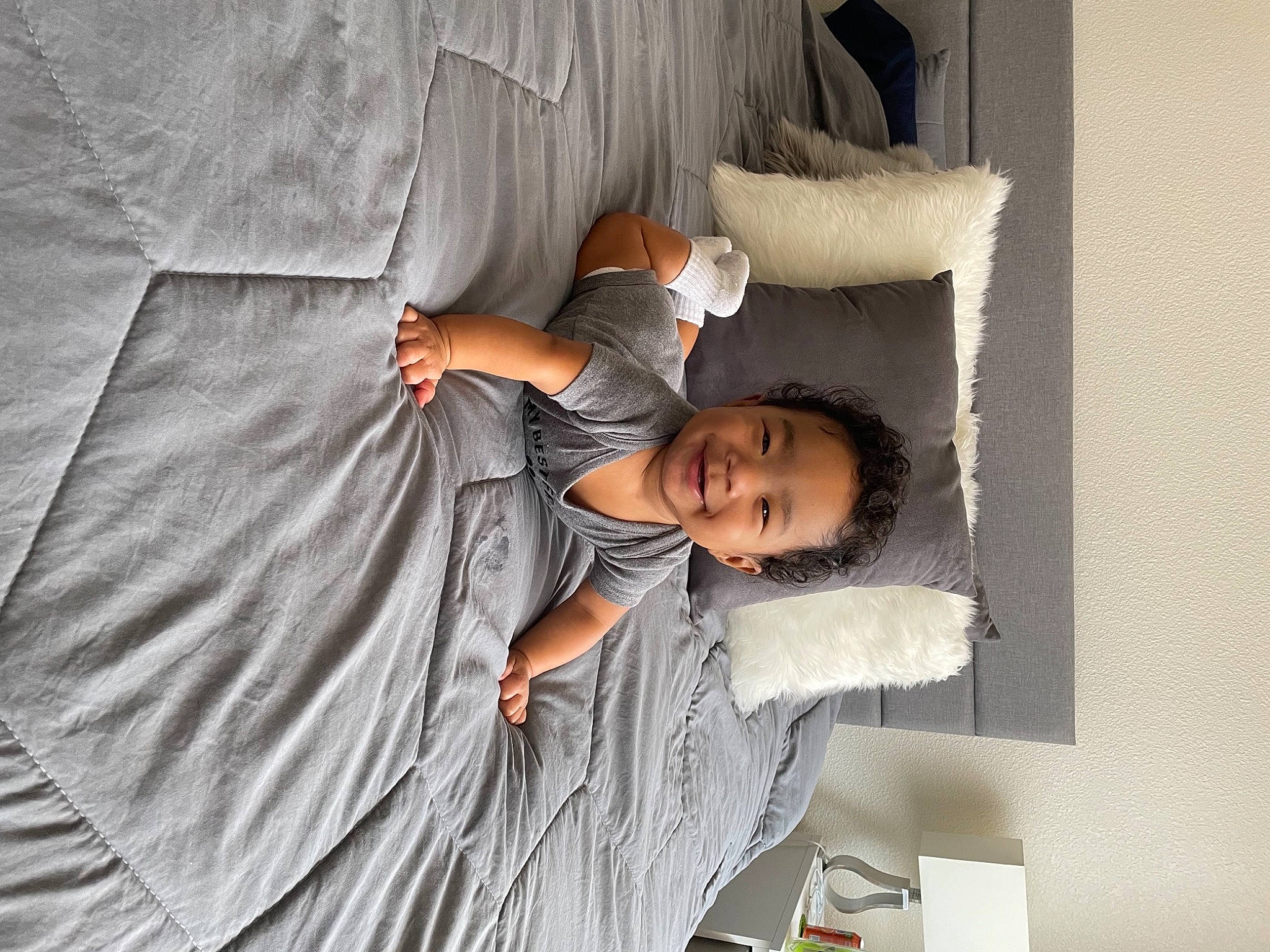 Kenzo is registered to the contest to win money with this photo: arm, bed, bed_frame, bed_sheet, bedding, bedroom, child, comfort, duvet, elbow, human_leg, joy, linens, mattress, nap, person, pillow, room, shoulder, t_shirt