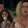 casual, clothing, cone, face, friends, glasses, hair, hairstyle, ice_cream, lipstick, night, outdoor, park, people, person, selfie, smiling, street_light, table, tattoo