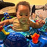 Caspian is registered to the contest to win money with this photo: baby, child, curly_hair, activity_center, toy_octopus, orange_star_toy, blue_toys, indoor, playtime, infant, clothing, face, person, cute, smiling_toy, home, furniture, colorful, fun, happy