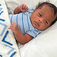 Marshawn joined the competition — help win amazing prizes! baby, infant, blanket, blue_stripes, clothing, face, fist, hair, laying_down, looking, newborn, person, portrait, skin, soft_surface, toddler, white_blanket, young_child, indoor, cute