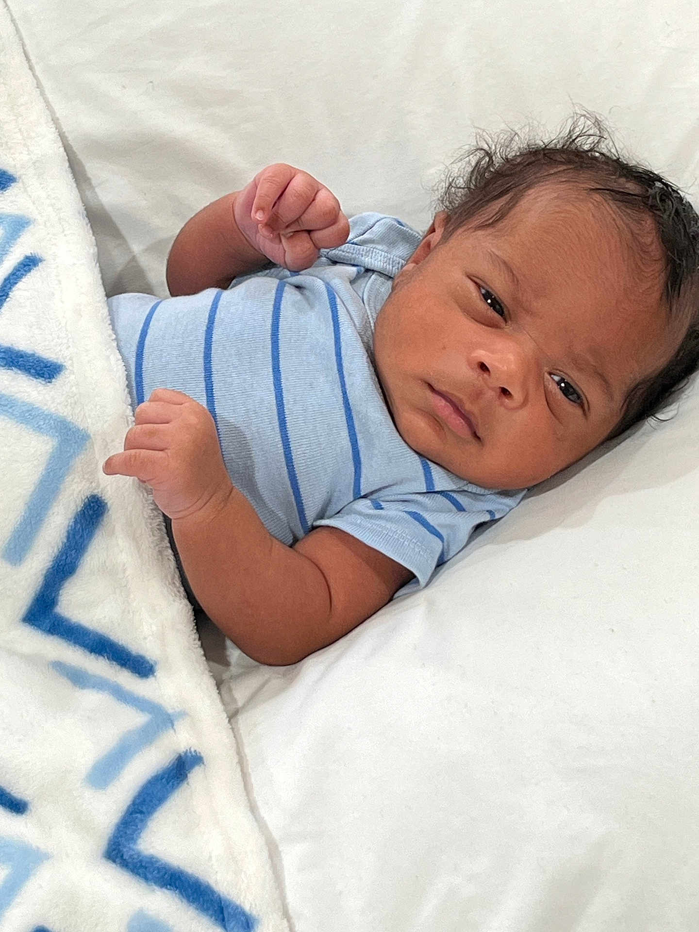 Marshawn joined the competition — help win amazing prizes! baby, infant, blanket, blue_stripes, clothing, face, fist, hair, laying_down, looking, newborn, person, portrait, skin, soft_surface, toddler, white_blanket, young_child, indoor, cute