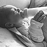 newborn, baby, infant, bottle, feeding, milk, sleepy, lying_down, blanket, swaddled, hands, face, portrait, black_and_white, monochrome, indoor, soft_light, close_up, clothing, resting