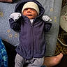 Havick joined the competition — help win amazing prizes! newborn, baby, infant, child, portrait, lying_down, winter_clothing, hat, hood, jacket, mittens, striped_pants, blanket, star_pattern, bed, indoor, adult_hands, adult_feet, cozy, face