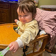 Garance a rejoint le concours — aidez-le/la à gagner de superbes lots ! baby, blanket, cabinet, child, face, floor_tiles, hair, happy, high_chair, indoor, ironing_board, person, pink_jacket, reaching_hand, room, smiling, spoon, table, wooden_furniture, yellow_clothing